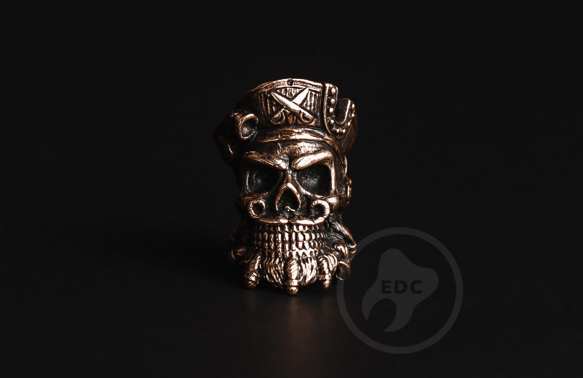 Close-up of the detailed beard and skull features on the brass pirate EDC bead.