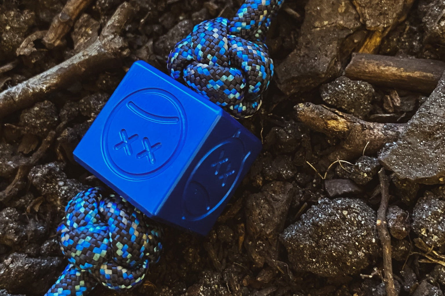 Blue Afrankart style aluminum cube bead resting on a flat surface.