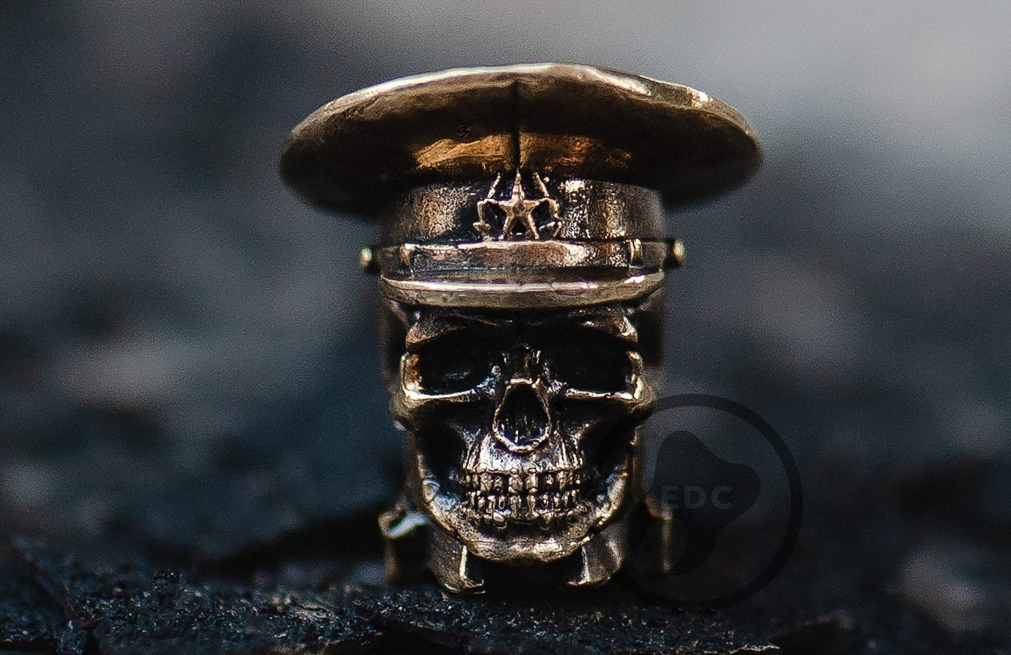 Brass skull bead wearing a military peaked cap with a star cockade.-1