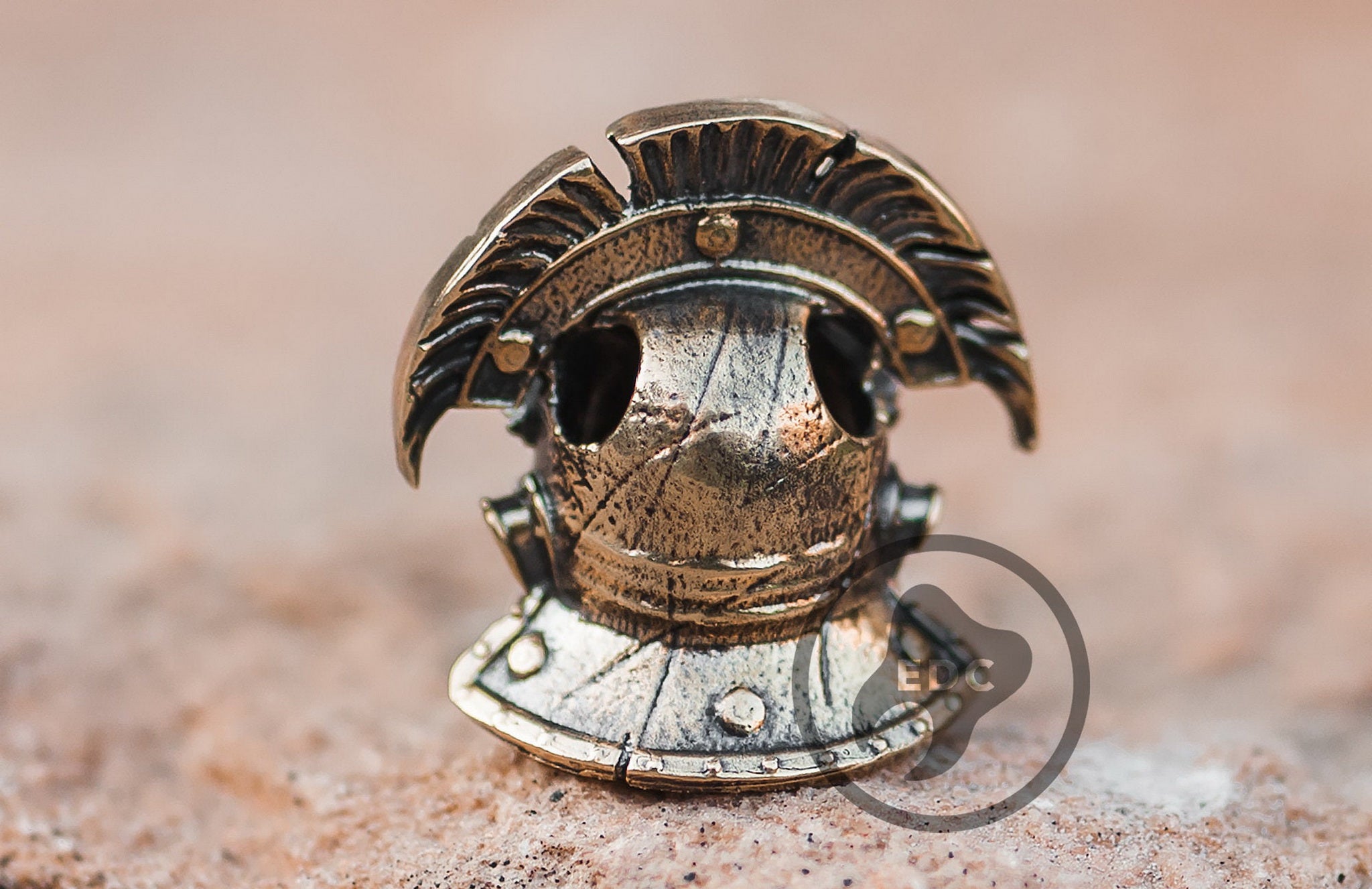 Close-up of the skeletal face and helmet crest on the Centurion brass bead.-1