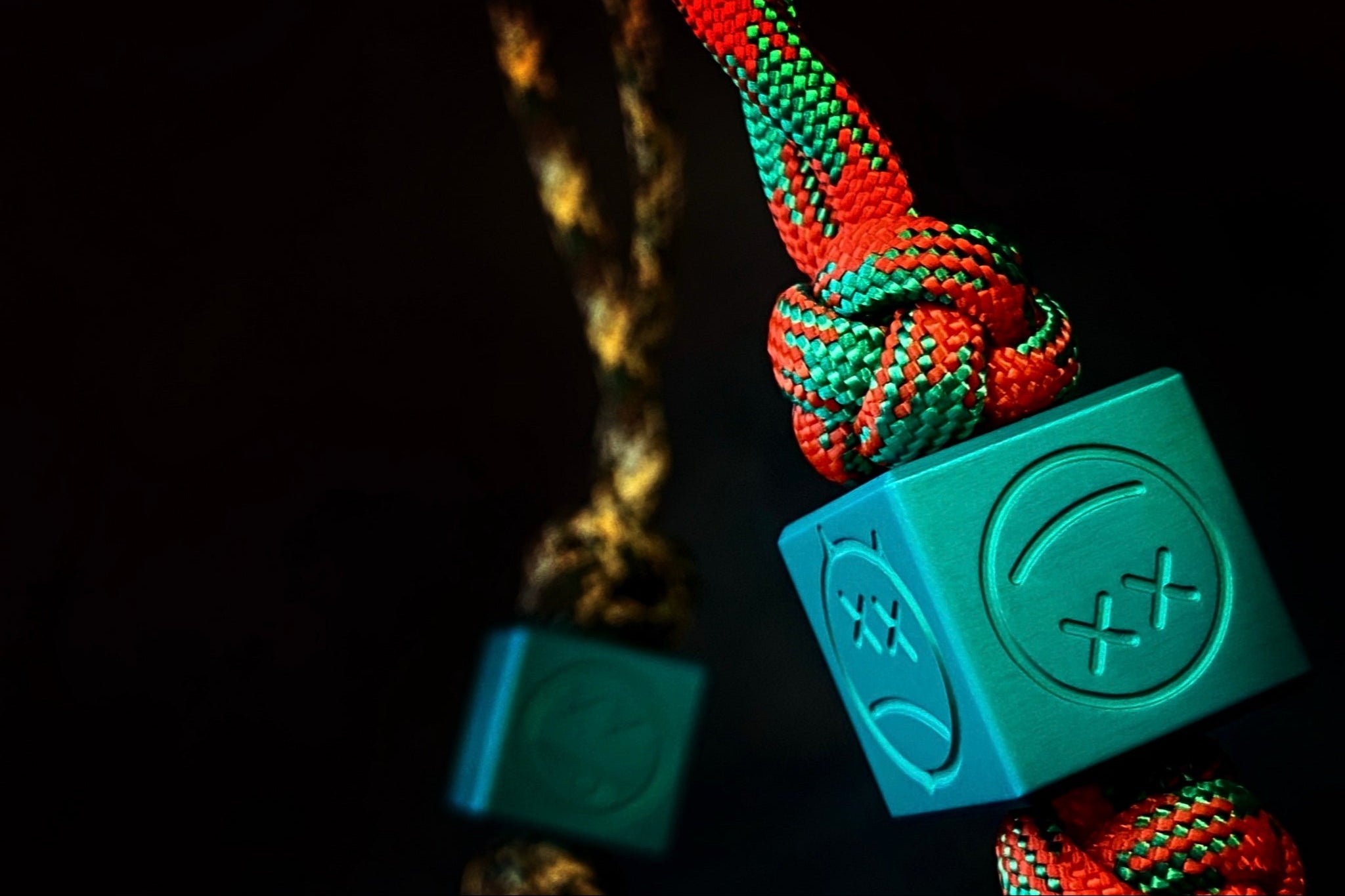 Matte teal aluminum Sad Face bead showing the top 6mm lanyard hole.-1