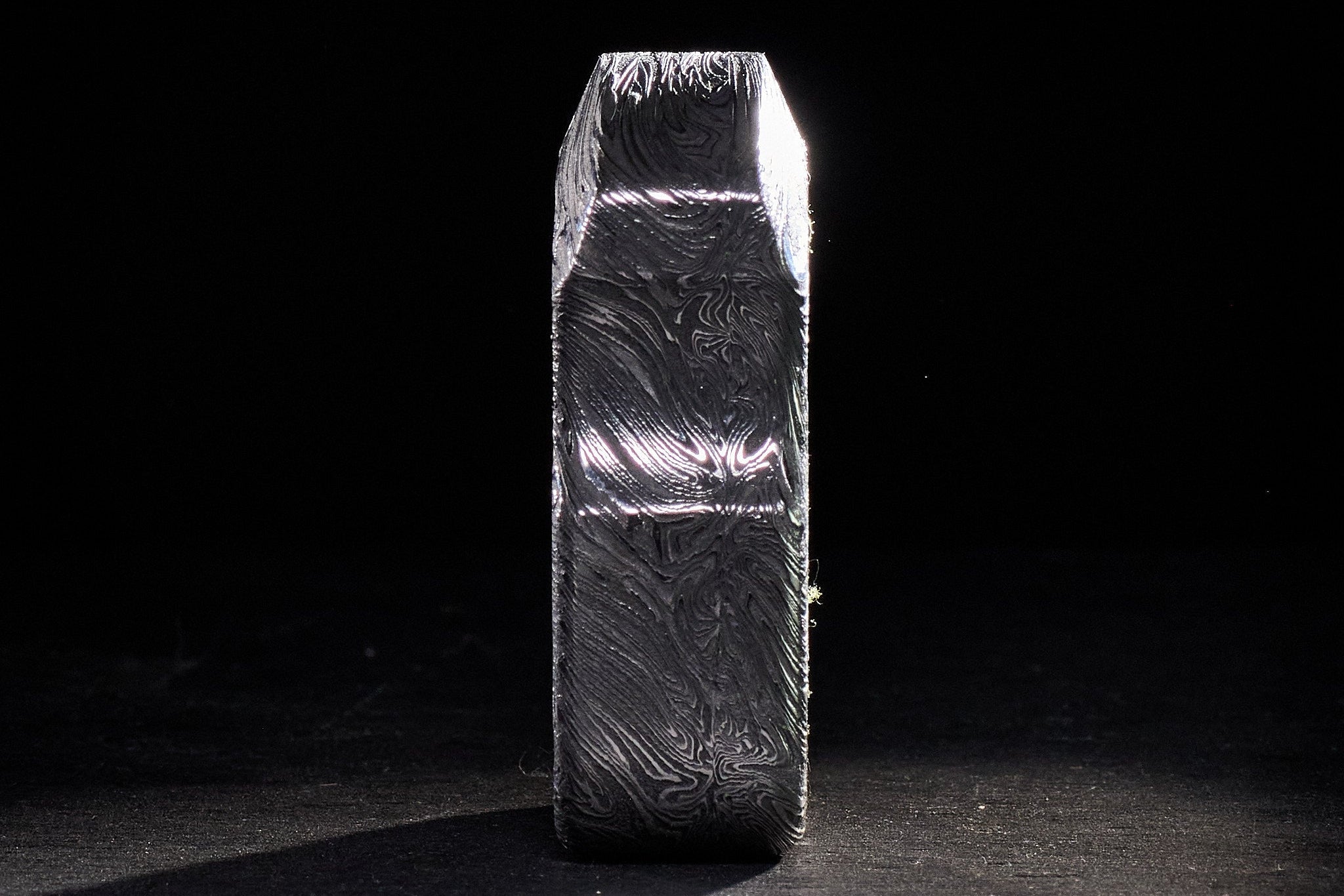 Close-up of high-contrast acid-etched Damascus steel layers on an S01 tool.