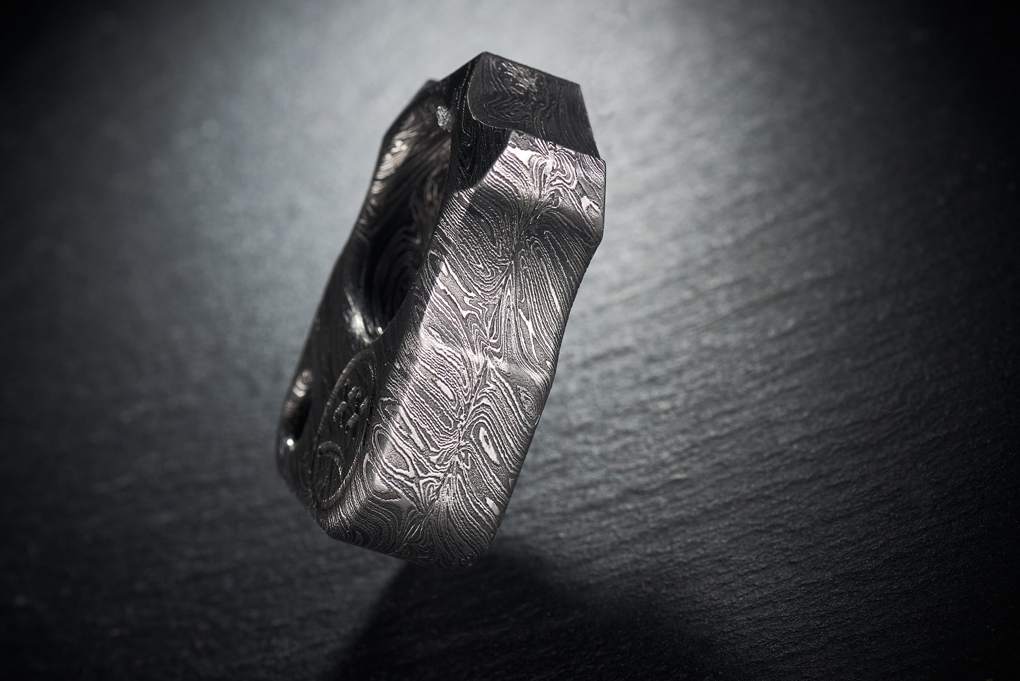 Close up of hand-etched Sad Face logo on high-contrast Damascus steel-4