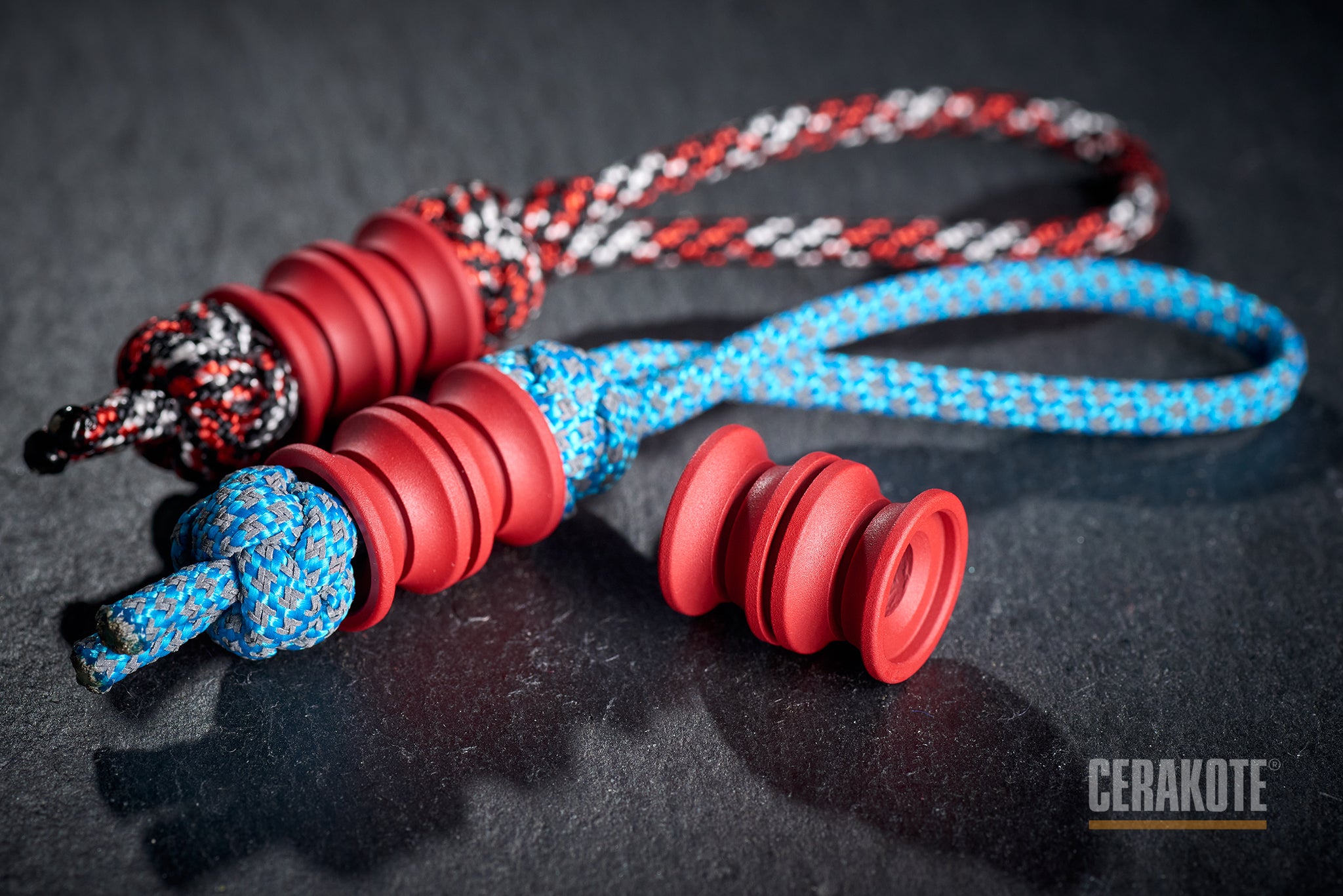 Red Grooved Barrel bead attached to a black paracord.
