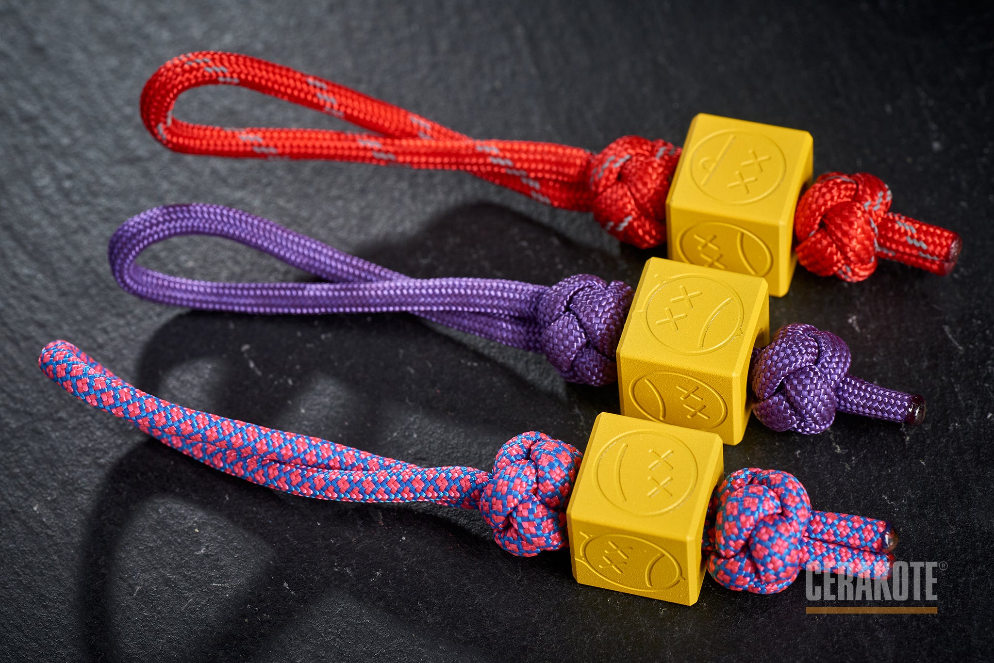 Yellow Sad Face Cube bead attached to a black paracord lanyard.-1