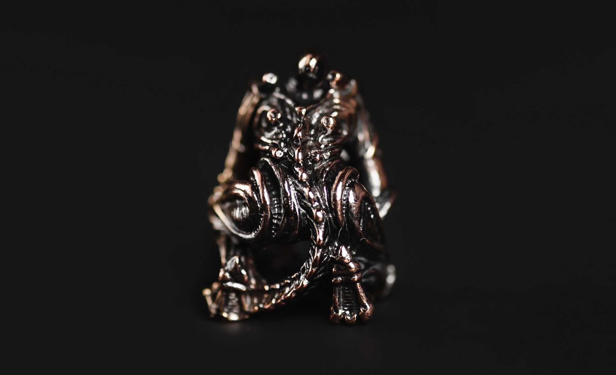Profile view of the elongated Alien head brass bead showing the antique blackened finish.-2