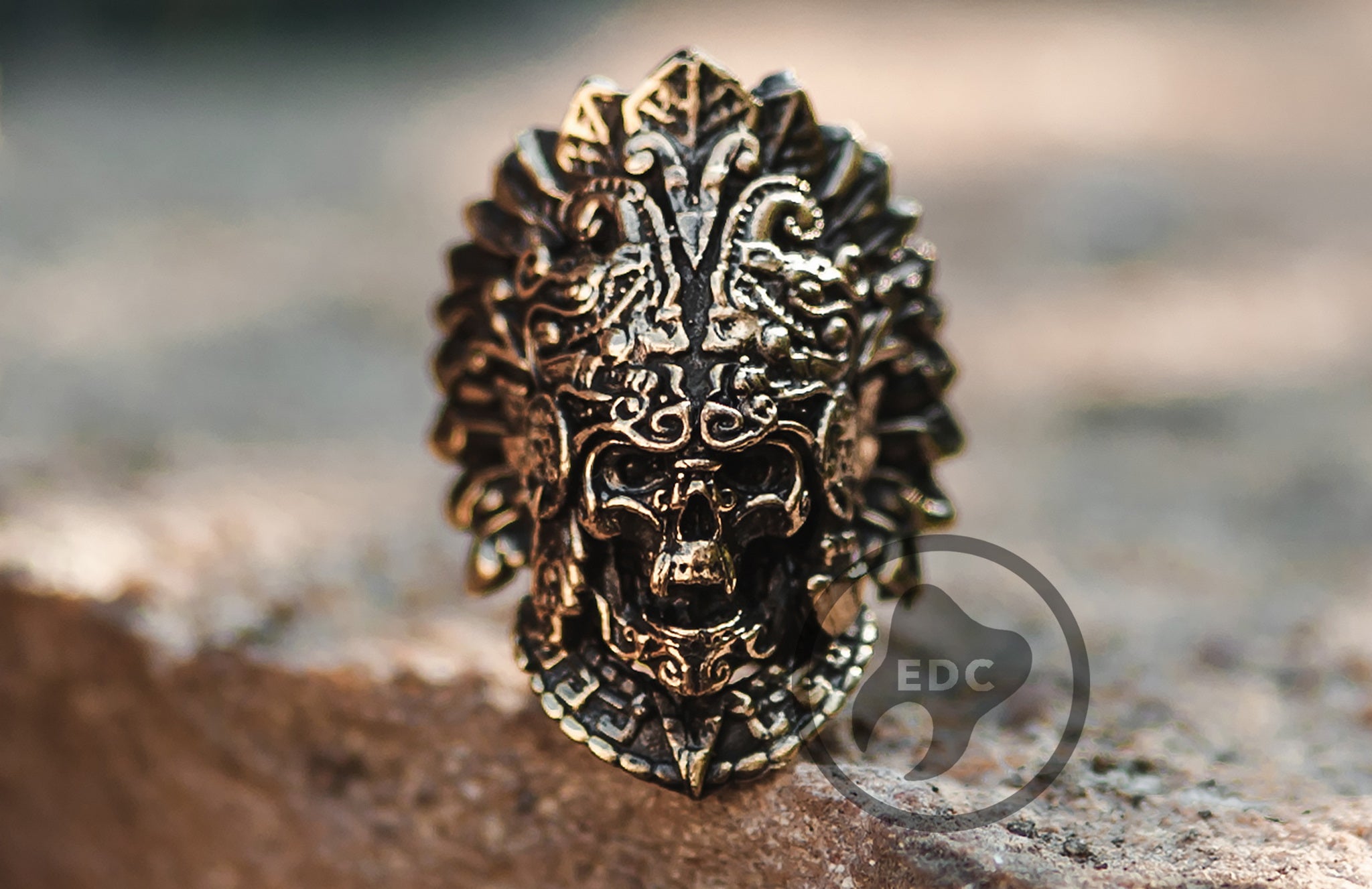 Hand-casted brass lanyard bead featuring an Aztec Priest skull holding a ritual heart.
