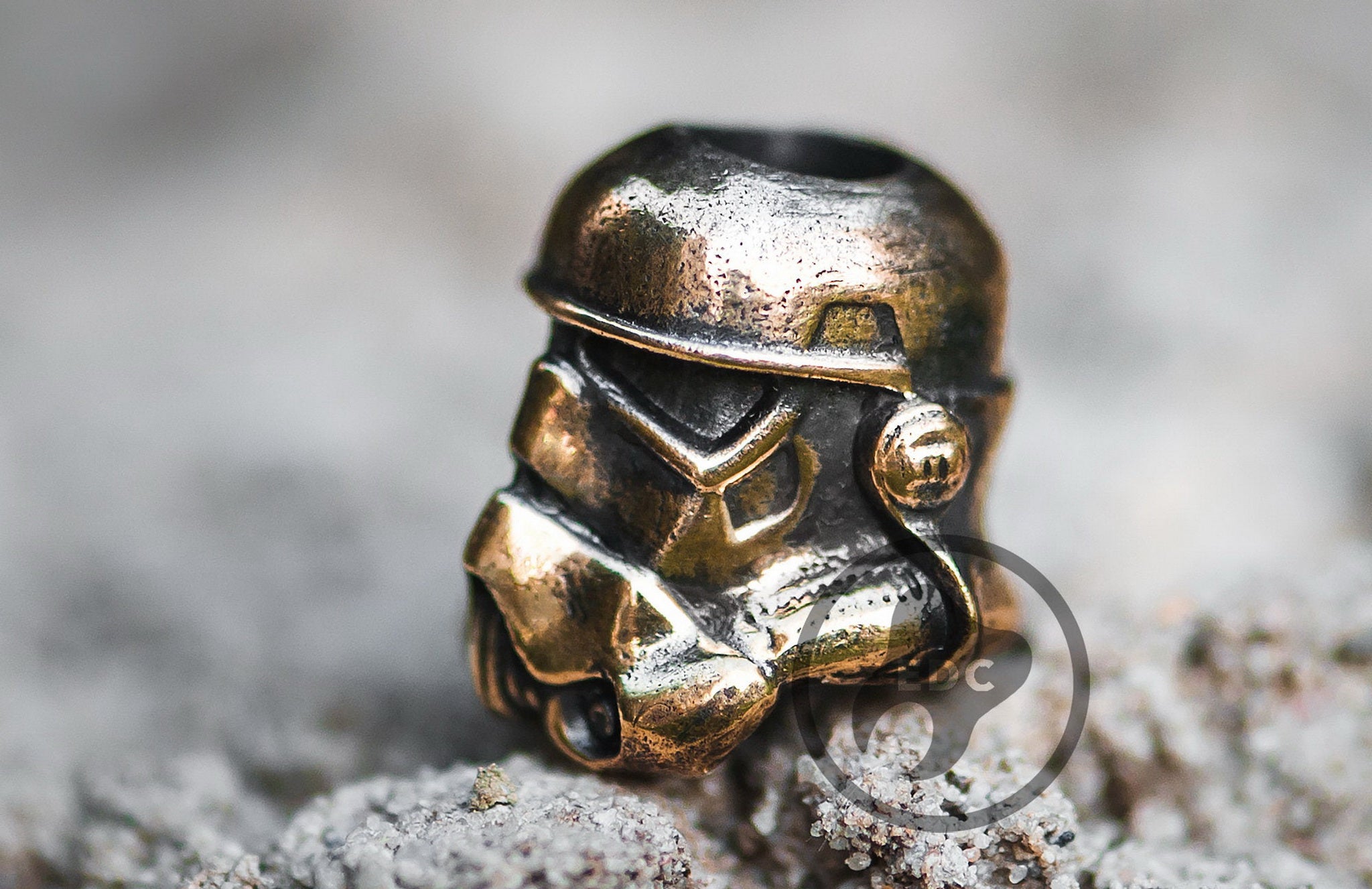Hand-casted brass lanyard bead in the shape of an Imperial Galactic Soldier helmet.
