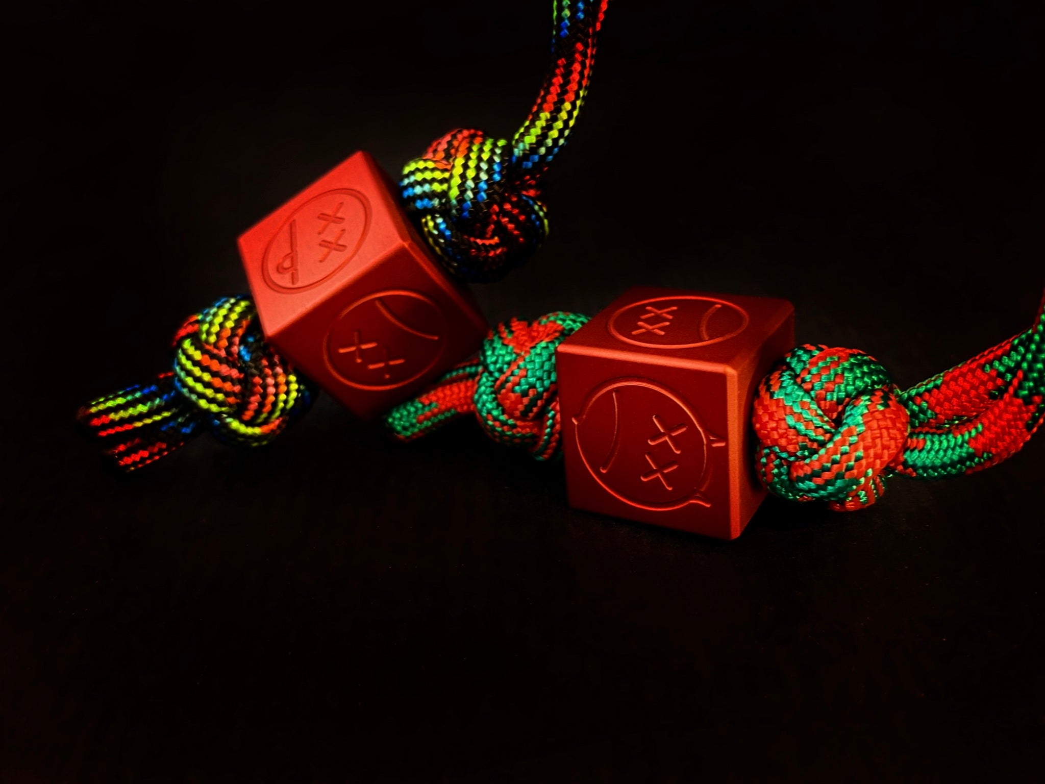 Matte red aluminum Sad Face bead showing the top 6mm lanyard hole.