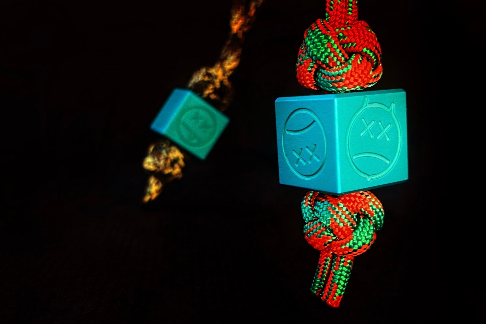 Matte teal aluminum Sad Face bead showing the top 6mm lanyard hole.
