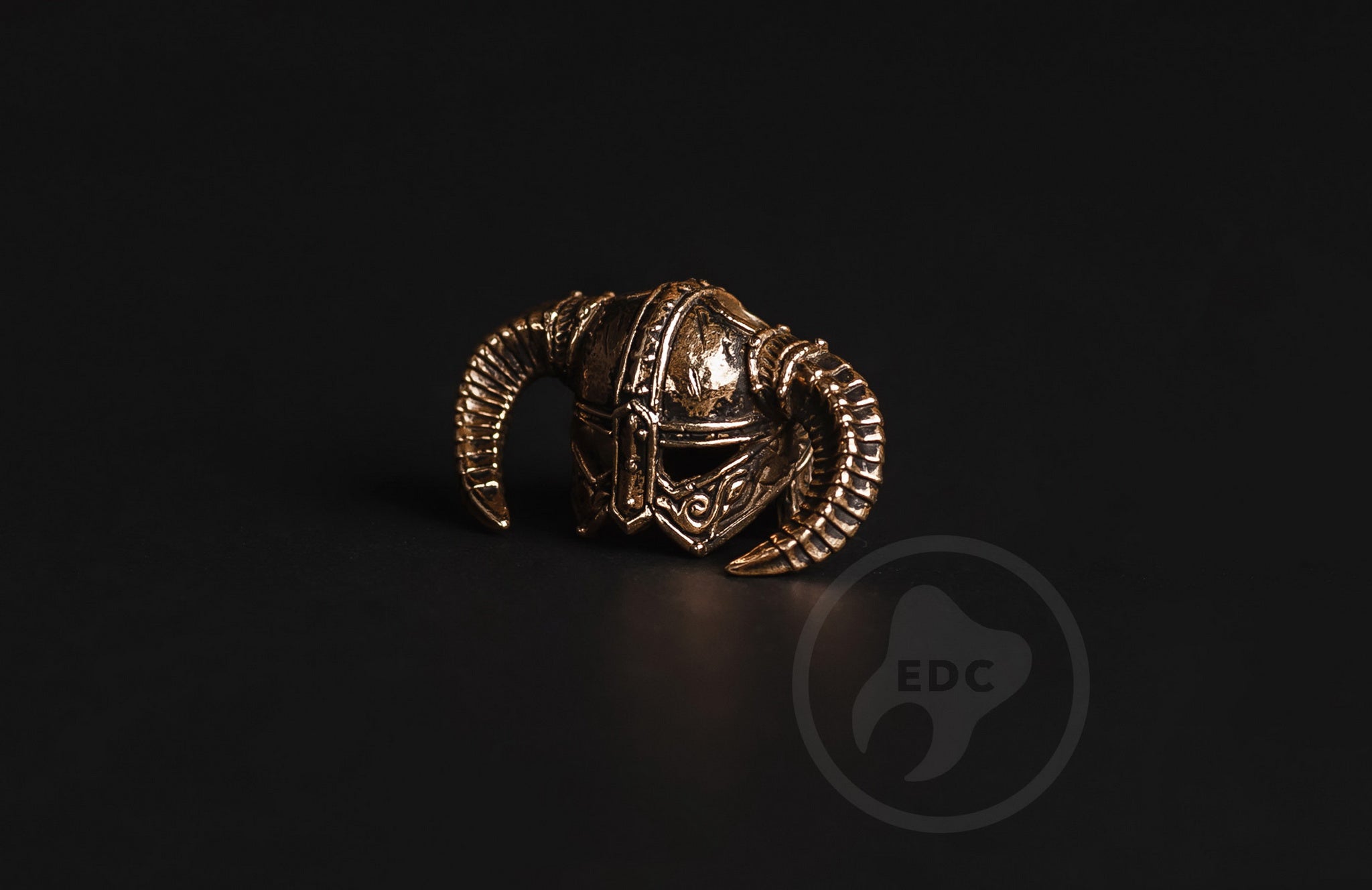 Profile view of the iron-style horns on the brass fantasy helmet EDC bead.