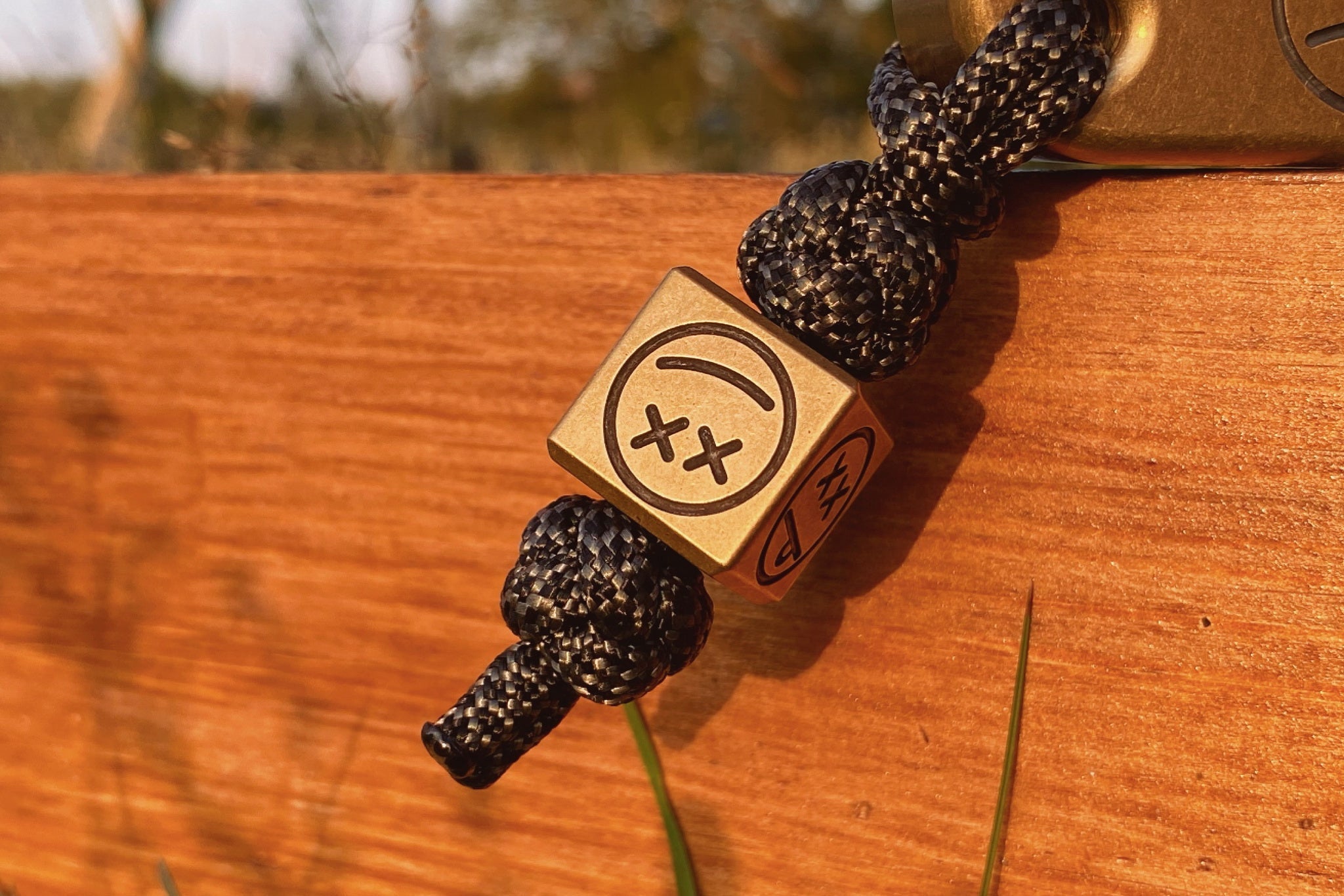 Heavyweight 40g patina brass cube used as a lanyard bead for a pocket knife.