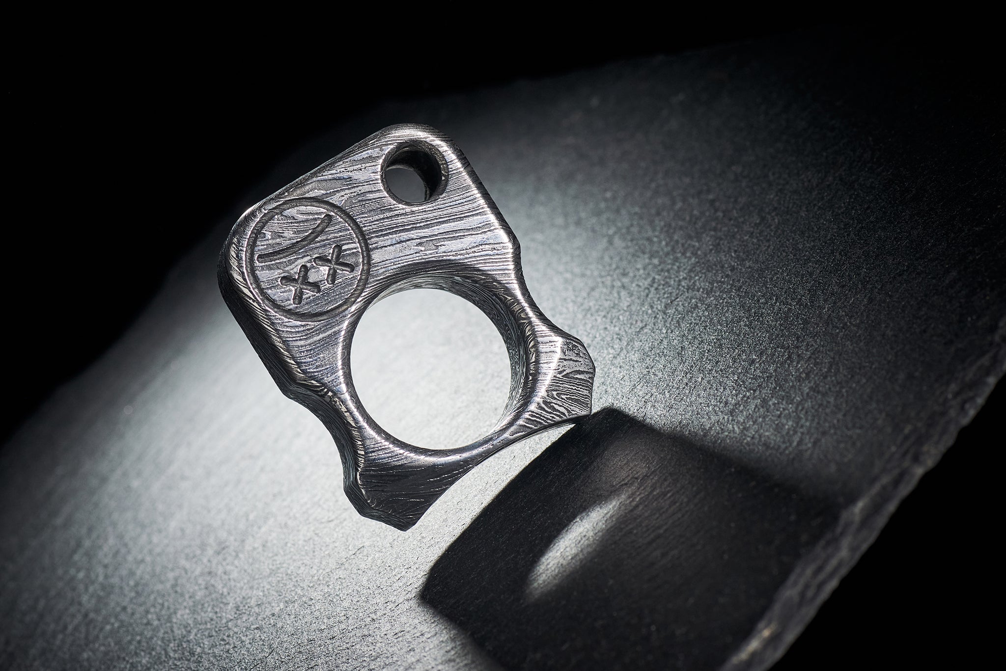 Series S02 Damascus steel pocket art with precision-milled Sad Face logo hallmark