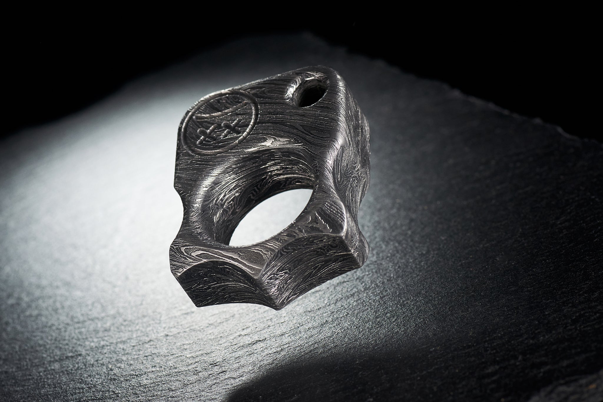 Close up of hand-etched Sad Face logo on high-contrast Damascus steel-2