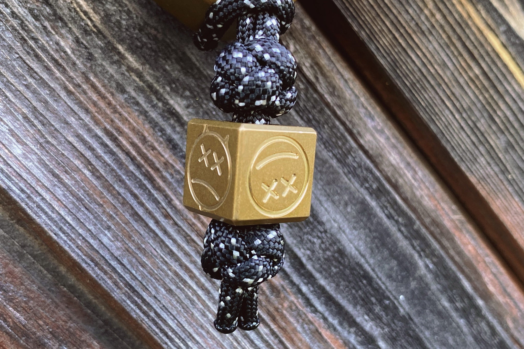 Close-up of the industrial tumbled texture on the brass EDC cube bead.