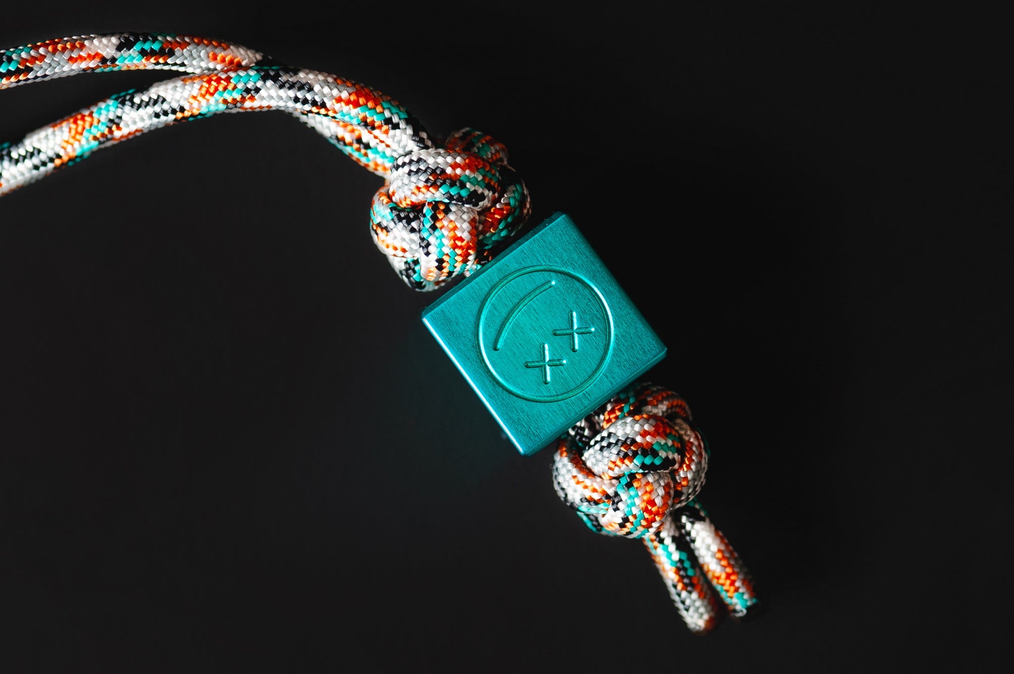 Macro shot of the vibrant teal metallic finish on a custom aluminum bead.