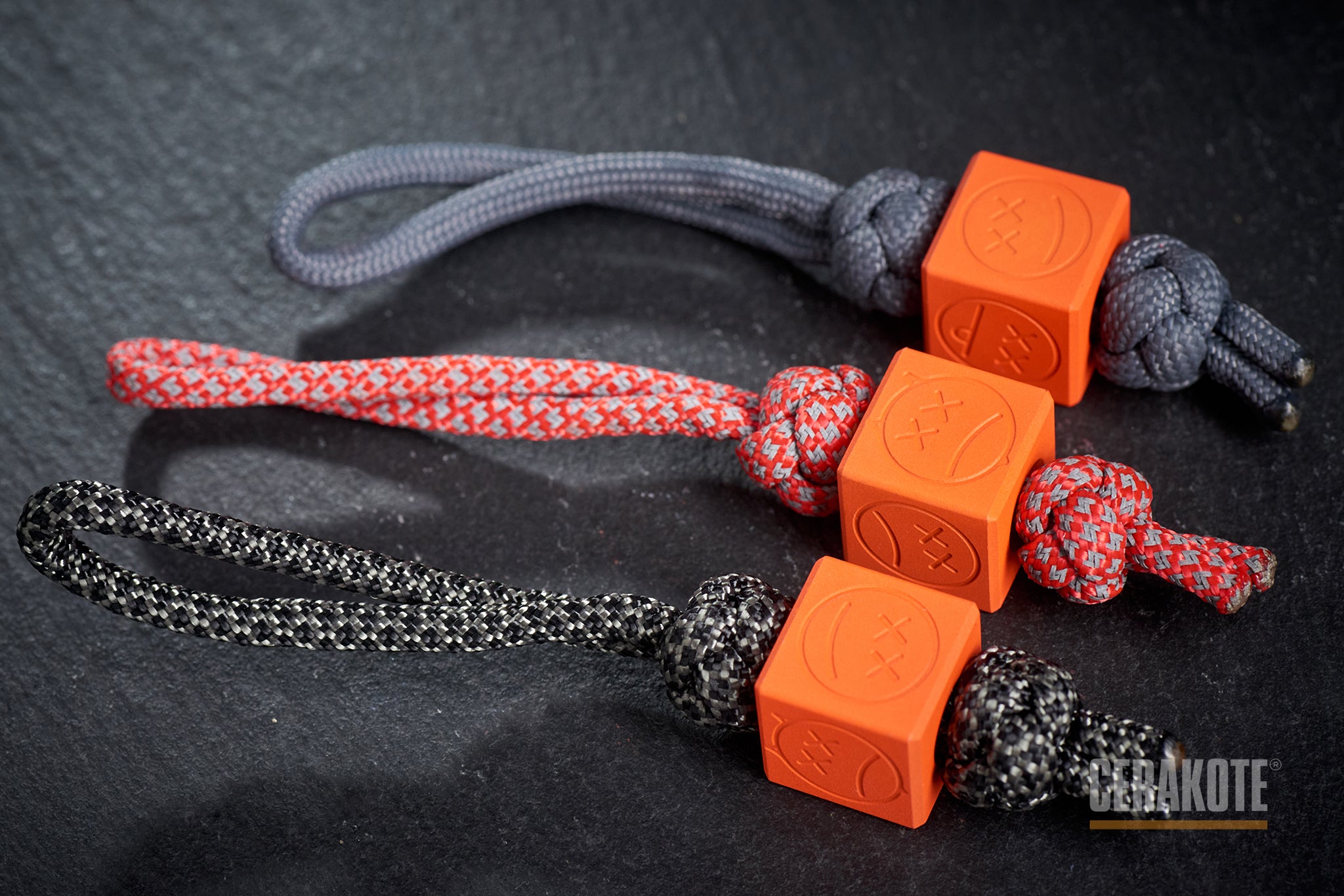 Orange Sad Face Cube bead attached to a paracord lanyard.-1