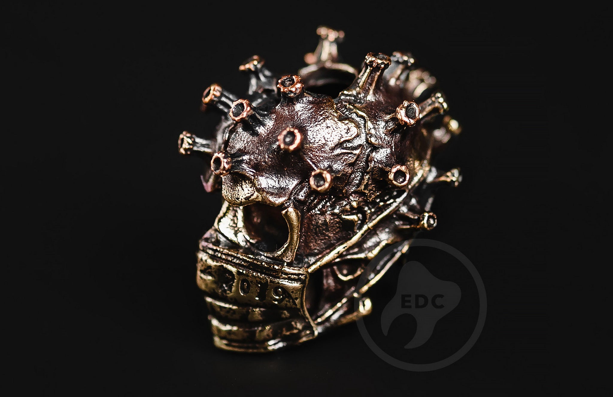 Profile view of the masked biohazard skull bead showing the antique blackened finish.