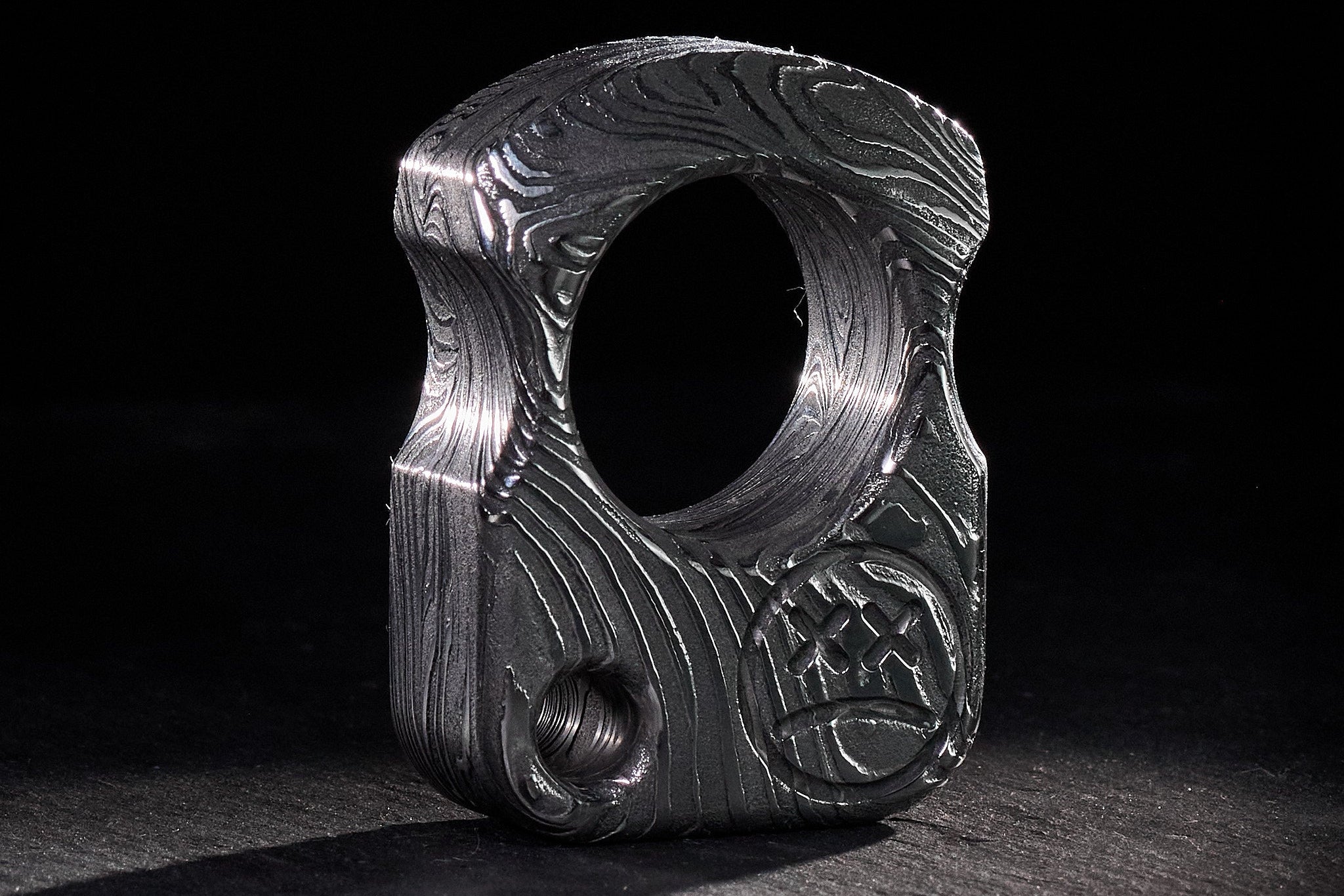 Precision CNC-milled forged Damascus steel pocket gear with unique high-contrast grain.