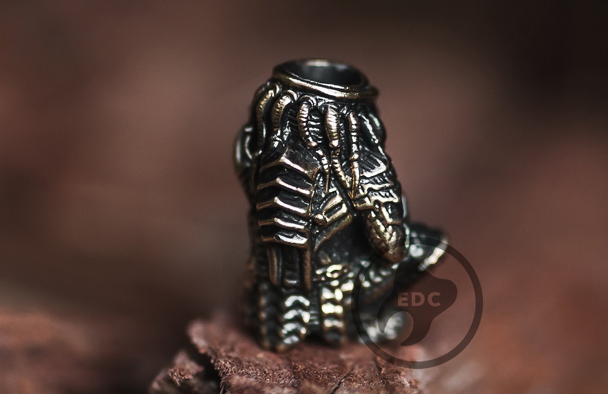 Solid brass Yautja Hunter Predator bead holding a human skull trophy.-1